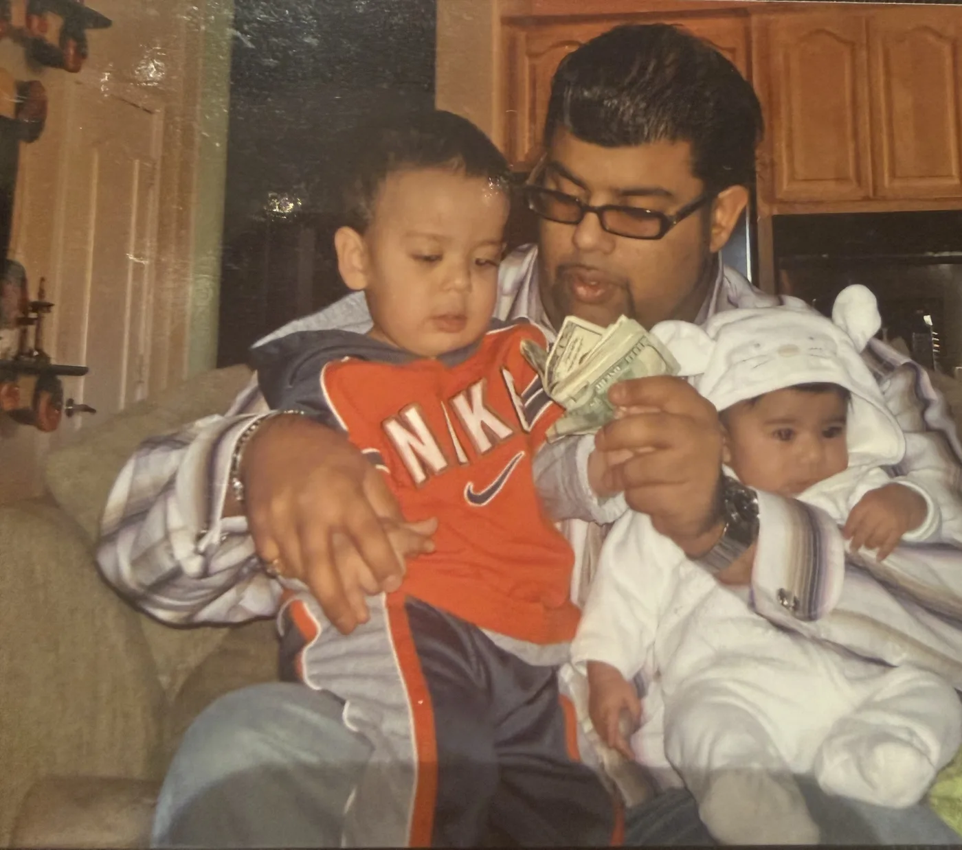 Family photo of Rocky V. Bawa as a toddler reaching for cash in his father's hand